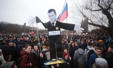 A portrait of Dmitry Medvedev is held aloft during a demonstration in St Petersburg