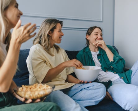 Three friends socialising with a bowl of popcorn