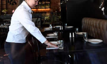 A waiter sets up a table at a restaurant