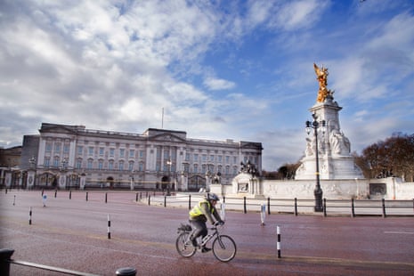 A cyclist on a largely deserted street outside Buckingham Palace in London today.