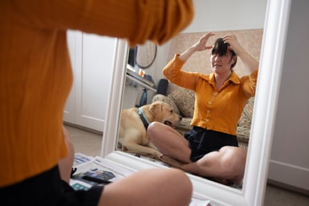 Journalist Caitlin Cassidy attempting to cut her own fringe at home in front of a mirror.