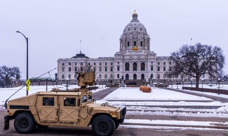Members of the Minnesota National Guard drive by the Minnesota Capitol building before an expected gathering of Trump supporters in St. Paul.