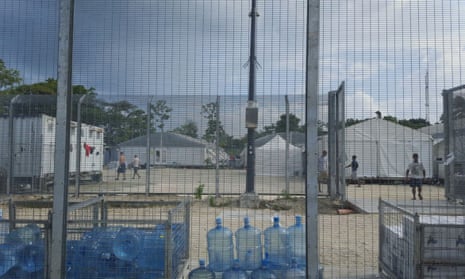 Detainees walk around the compound among water bottles inside the Manus Island detention centre in Papua New Guinea,