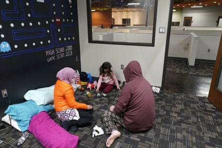 Novi Harris, left, her husband, Christopher, right, and their daughter, Keeva, occupy an office suite at a pop-up warming center in Richardson, Texas, on Tuesday.