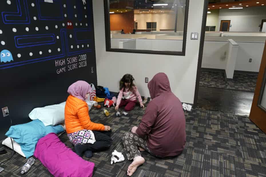 Novi Harris, left, her husband, Christopher, right, and their daughter, Keeva, occupy an office suite in a pop-up warming center in Richardson, Texas, on Tuesday.