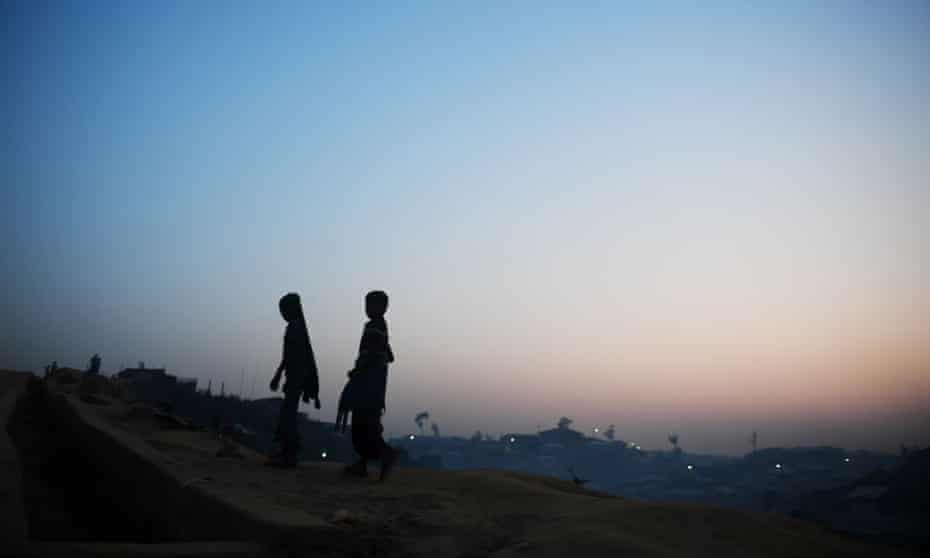 Rohingya refugees walk back to their tent during dusk at the Kutupalong refugee camp 