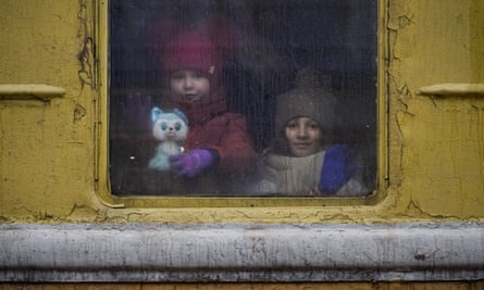 Children look out the window of a train in Kyiv, Ukraine.