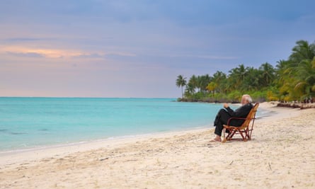 Narendra Modi sitting barefoot in a deckchair on an idyllic-looking Indian Ocean beach