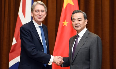 China’s foreign minister Wang Yi shakes hands with British foreign secretary Philip Hammond