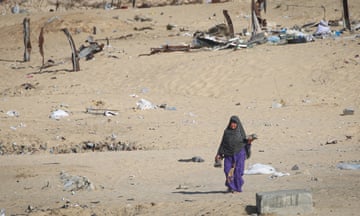 A displaced Palestinian woman leaves a dismantled camp in Rafah