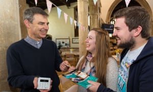 Martyn Taylor, Rector at St George's Church in Stamford, Lincolnshire holding a contactless payment device