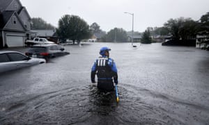 A search and rescue worker wades through a flooded neighborhood in Fayetteville, North Carolina.