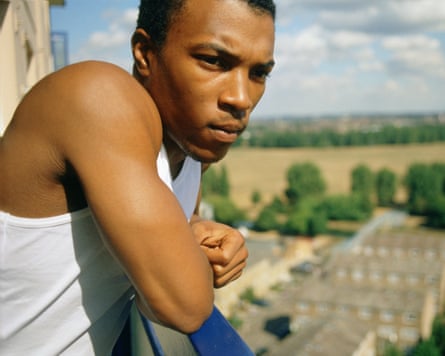 Ashley Walters looks down from a balcony on an estate