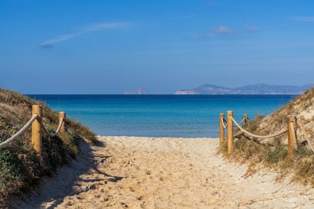 Beach access leads to a beach with a view of Ibiza and Es Vedra in the background