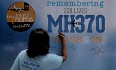 A family member writes on a message board during the five-year memorial event for the missing Malaysia Airlines flight MH370 in Kuala Lumpur.