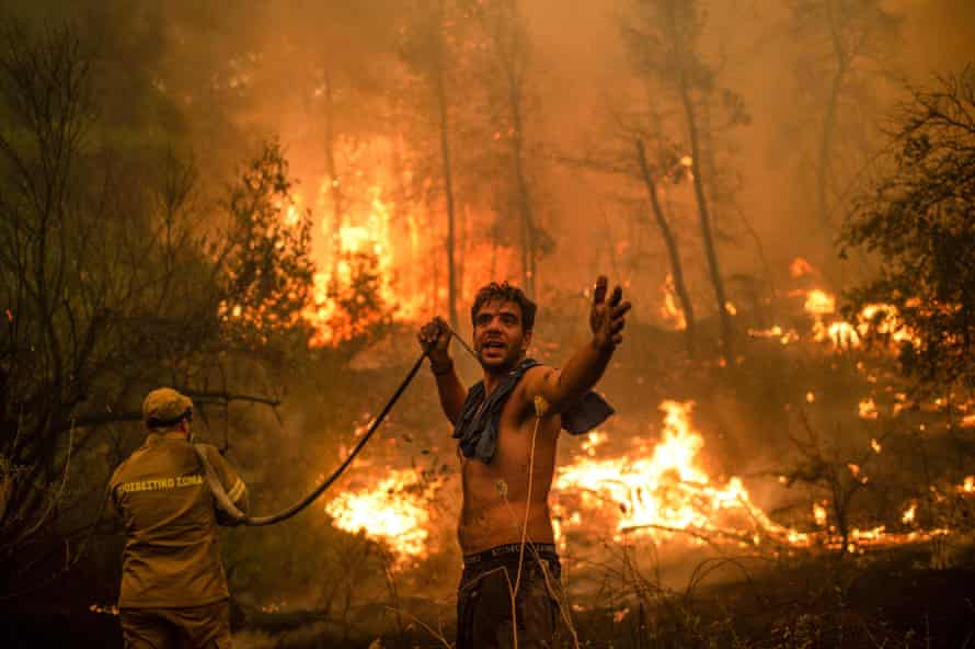 Um morador local segura uma mangueira de água vazia perto da vila de Pefki, na Grécia.