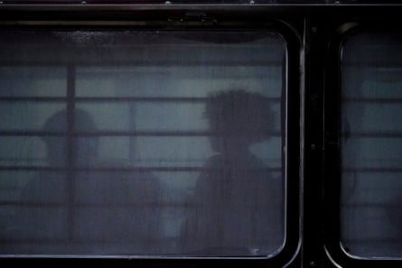 People are seen through the windows of a bus after they were detained at an immigration court in June. The Trump administration is encouraging people to ‘self deport’ as part of its mass immigration crackdown.