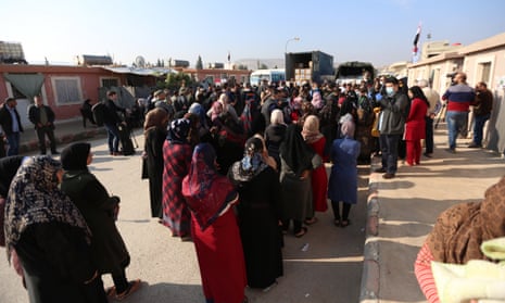 Refugees line up to receive humanitarian aid in Syria.