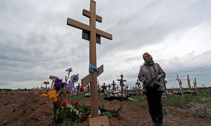 Natalia, 57, stands by the grave of her son at a cemetery in the course of Ukraine-Russia conflict in the settlement of Staryi Krym outside Mariupol, Ukraine May 22, 2022.