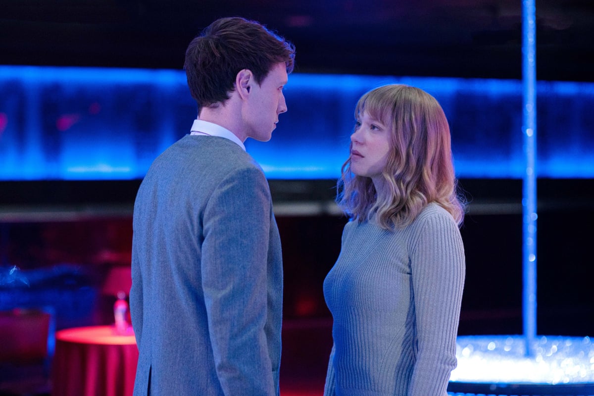 A man and a woman both dressed in grey staring intensely at each other