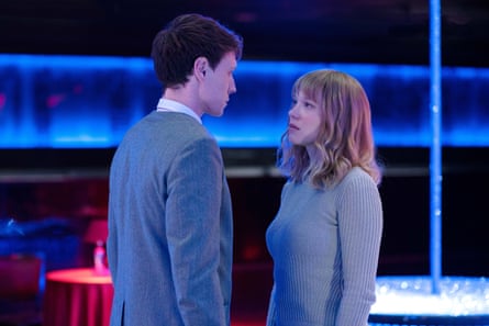 A man and a woman both dressed in grey staring intensely at each other