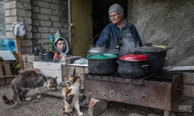 A family cooking outside the basement of their house in Izium.