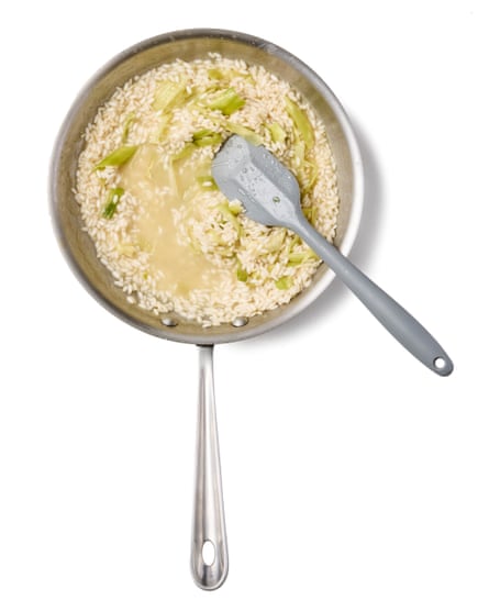 Adding stock, bit by bit, to the rice to the pan