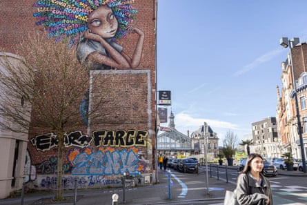 A view of graffiti on the side of a building with the train station in the background