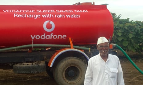 A farmer stands beside one of Vodafone's water tankers