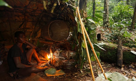 Baka man taking shelter in a Mongolu at a forest hunting camp, Cameroon.