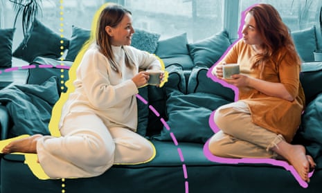 Two women sitting on a couch with cups of tea