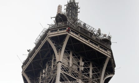 A rescue worker hangs from the Eiffel Tower