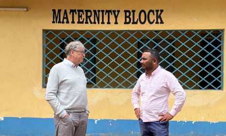 Amol Rajan and Bill Gates talk in front of a concrete building signed Maternity Block.
