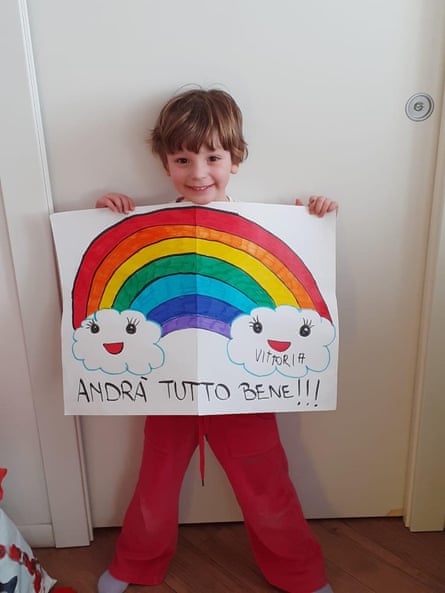 A child holding up an encouraging rainbow drawing.