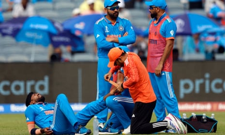 India's Hardik Pandya receives medical attention after sustaining an injury as Rohit Sharma and Mohammed Shami look on.