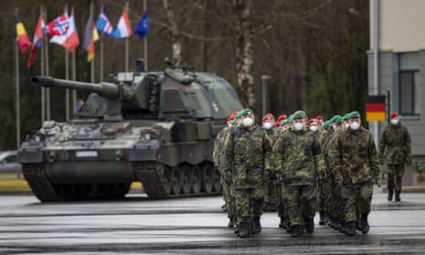 German Bundeswehr soldiers of the NATO enhanced forward presence battalion waits to greet German Defense Minister Christine Lambrecht upon his arrival at the Rukla military base some 100 kms (62.12 miles) west of the capital Vilnius, Lithuania, Tuesday, Feb. 22, 2022. Germany is sending additional troops to Lithuania in response to Russia's military build-up on the border with Ukraine and the worsening security situation in the Baltic states. (AP Photo/Mindaugas Kulbis)