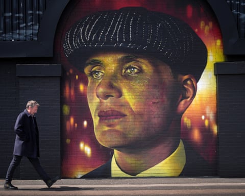 Steven Knight walks past a Peaky Blinders mural in Birmingham, England.