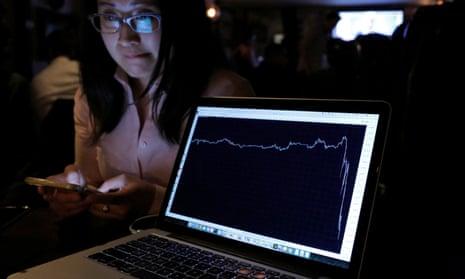 A woman in New York watches the pound fall on a laptop