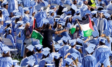 Palestinian flags are taken from protesters as they walk out of UNC Chapel Hill's commencement ceremonies at Kenan Stadium in Chapel Hill, N.C., Saturday, May 11, 2024. (Ethan Hyman/The News &amp; Observer via AP)
