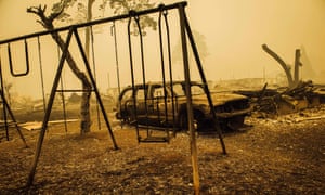 Charred swing set and burnt-out car