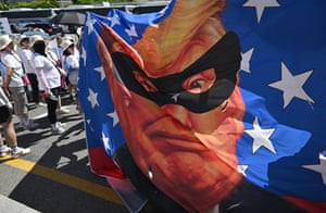 A large banner showing Donald Trump with a mask over his face