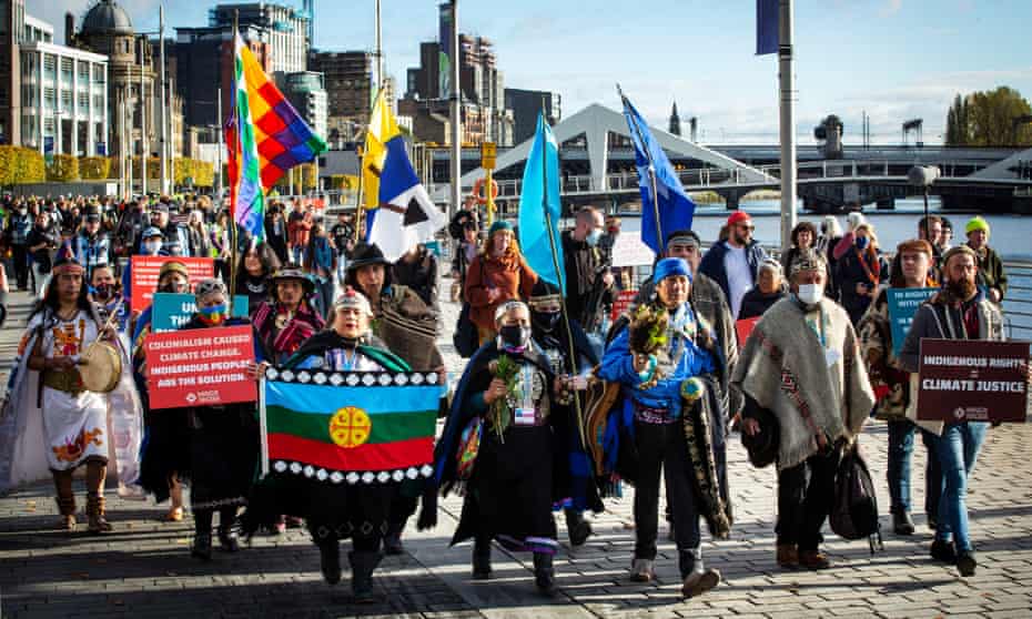 Indigenous leaders march in ceremonial dress to the Cope Scottish Event Campus.
