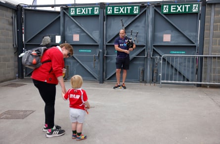 A young Welsh fan is introduced to a Scottish bagpiper playing before the Women’s Rugby World Cup 2025 Group B match between Scotland and Wales.