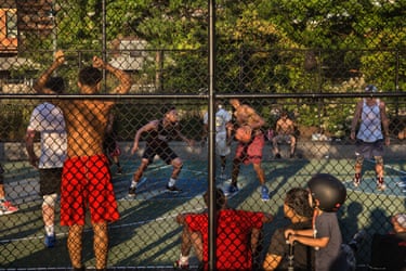 Manhattan, 2017. Children watching two young men confronting each other at basketball, seen through the court’s fencing