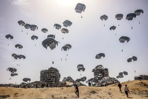Aid packages fall to the ground under parachutes