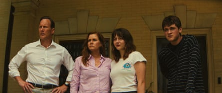 A man, a woman, a teenage girl and a teenage boy on a house's front porch