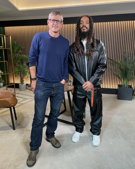 Louis Theroux and Bobby Vylan standing in a wood-panelled designer studio room