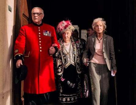 Jackie Murphy in her pearly outfit flanked by a Chelsea pensioner and another woman in a grey jacket and trousers
