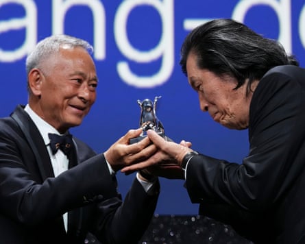 Johnnie To smiles as he presents the grand jury award to a bowing Lee Chang-dong