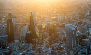 The sun rises over the City of London.